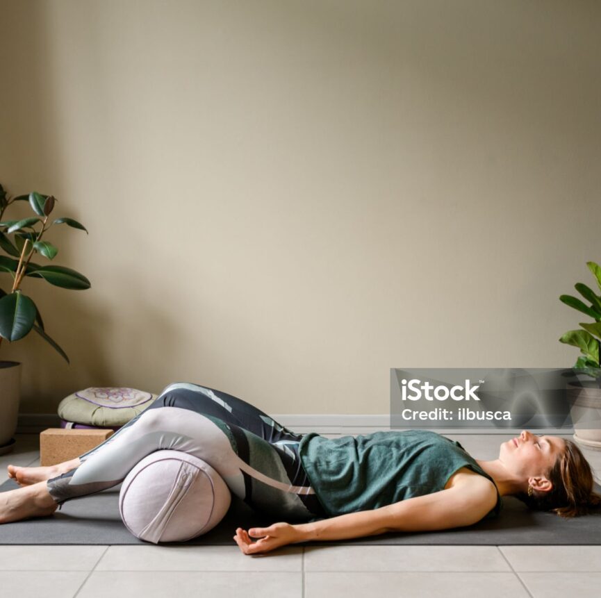Professional woman practicing yoga at home: Corpse, Shavasana